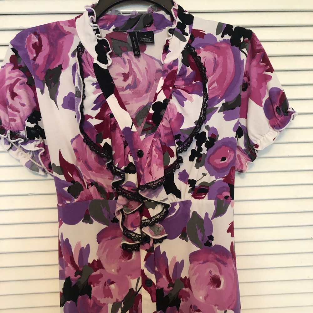 V neck, button down, short sleeved top with loose elastic sleeves. Back tie.